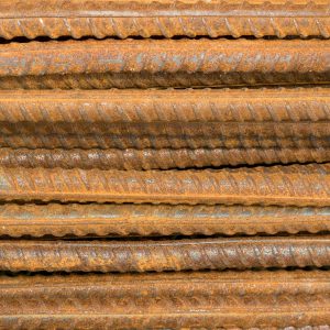 Rusted rebar is stacked horizontally.